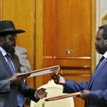 South Sudan's then-rebel leader Riek Machar (R) and South Sudan's President Salva Kiir exchange signed peace agreement documents in Addis Ababa in this May 9, 2014 file photo.
