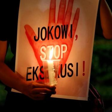 A protester holds a placard reading "Jokowi, stop executions" during a demonstration against Indonesia's decision to execute 14 drug convicts in front of the Presidential Palace in Jakarta, Indonesia, July 28, 2016.