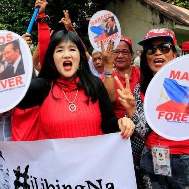 Supporters wave banners and signs with the image of the late dictator Ferdinand Marcos, as they wait for the decision of the justices on the proposed hero's burial for Marcos at the Libingan ng mga Bayani (Hereos cemetery), which was deferred on November 