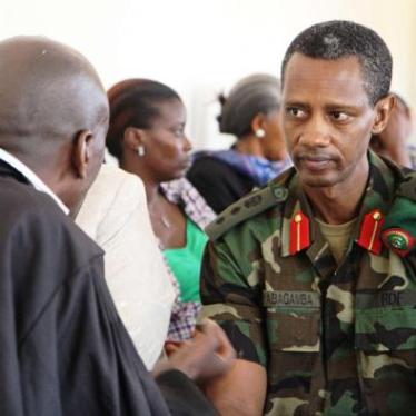 Col. Tom Byabagamba speaking to his lawyer before his hearing at the military court in Kigali on August 29, 2014.