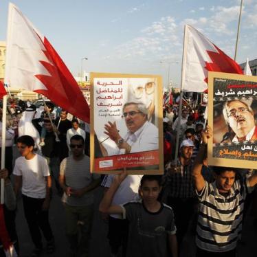 Protesters hold pictures of political prisoner Ebrahim Sharif as they participate in a protest held in the village of Sanabis, west of Manama, Bahrain on December 22, 2012. 