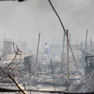 People walk among rubble in an United Nations base in the northeastern town of Malakal on February 18, 2016.