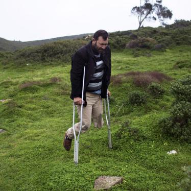 A Syrian man with one leg walks through the deserted Greek island of Pasas after he arrived with others from Turkey. 