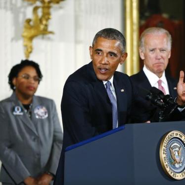 U.S. President Barack Obama stands with Vice President Joe Biden (R) and family members of shooting victims while delivering a statement on steps the administration is taking to reduce gun violence in the East Room of the White House in Washington January
