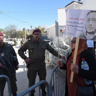 Tunisian protesters stand outside a military court in Tunis as they demonstrate in support of blogger Yassine Ayari during his appeal hearing on March 3, 2015. 