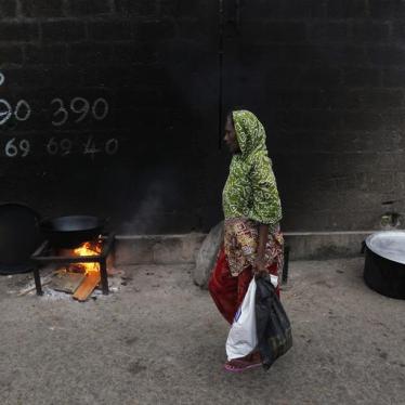 A woman walks past a cooking fire along a road during Eid al-Fitr in Colombo, Sri Lanka, August 8, 2013.