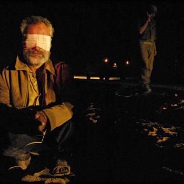 A blindfolded Palestinian, detained during an Israeli military operation in Gaza, sits on the ground at a crossing between Israel and the Gaza Strip on November 7, 2007. 