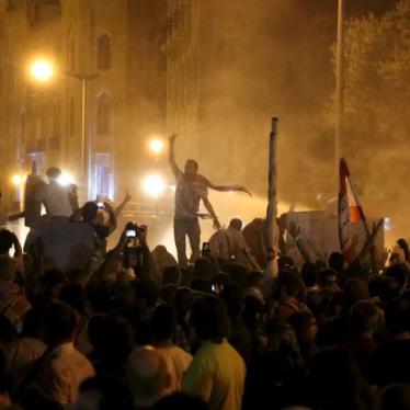 Protesters gesture with the victory sign as security forces fire water cannons in Martyr square, downtown Beirut, Lebanon