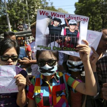 Protesters hold pictures of Zaw Lin and Win Zaw Htun as they protest in front of the Thai embassy in Rangoon on December 25, 2015. 