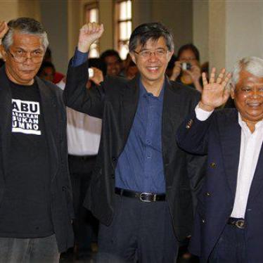 Social activist Haris Ibrahim, left, opposition leader Tian Chua, center, and Pan-Malaysian Islamic Party activist Tamrin Ghafar pose for photographers as they arrive at a court house in Kuala Lumpur, Malaysia, Wednesday, May 29, 2013. Prosecutors have fi