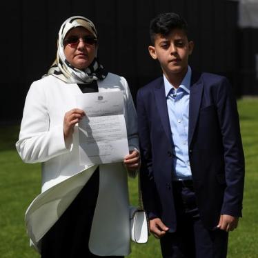Fatima Boudchar, wife of Libyan politician Hakim Belhadj, stands with their son Abderrahim, as she holds a letter of apology from Prime Minister Theresa May.