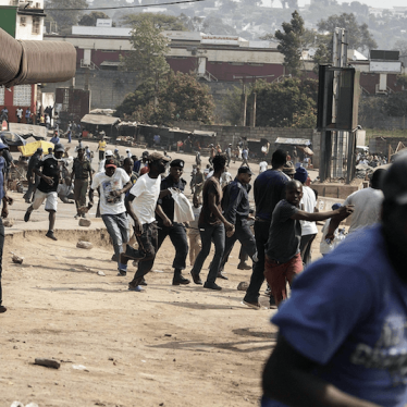 Protesters run for cover as they clash with eSwatini anti-riot police in Manzini, September 19, 2018. Undercurrents of dissent surfaced with trade union protests over low wages by being broken up by riot police. © 2018 GIANLUIGI GUERCIA/AFP/Getty Images