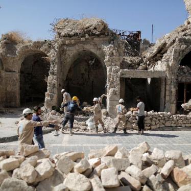 Workers remove rubble from a damaged shop in the old city of Aleppo, Syria.